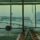 A large airplane is parked outside an airport terminal window at dawn.